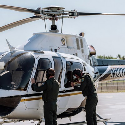 Two pilots leaning out helicopter door