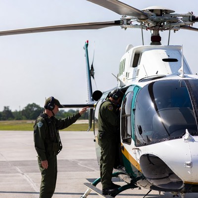 Two pilots boarding white helicopter