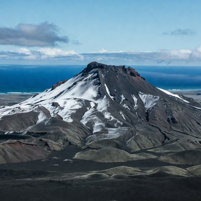 Snow-capped volcano overlooking ocean