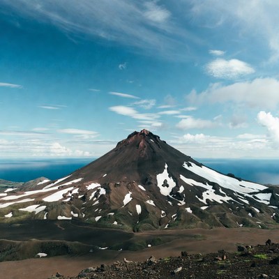 Snow-capped volcano overlooking ocean