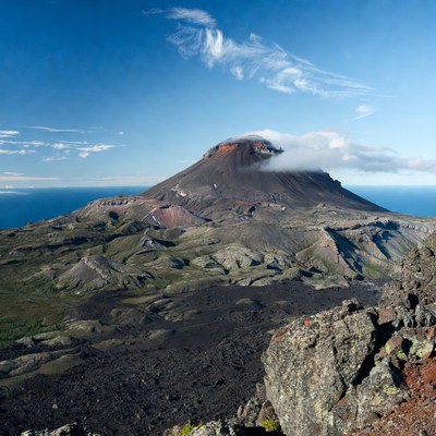 Active volcano erupting over ocean