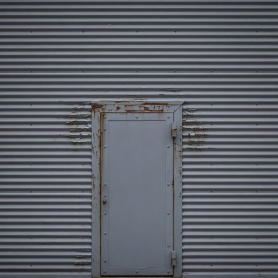 Rusty metal door on corrugated wall