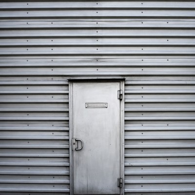 Silver metal door on corrugated wall