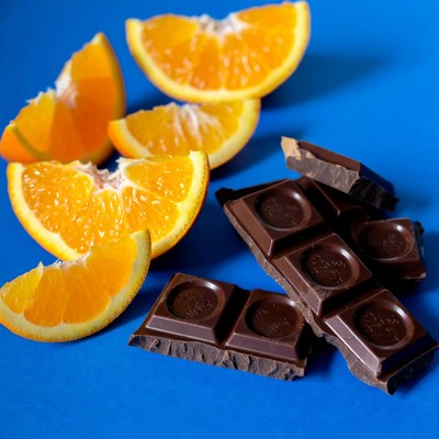 Orange slices and chocolate on blue background