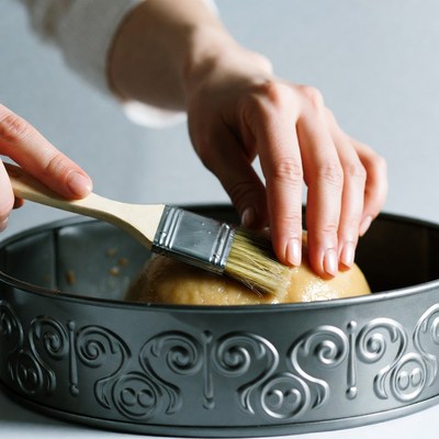 Woman brushing egg wash on dough