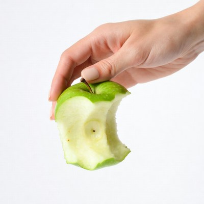 Woman's hand holding bitten green apple