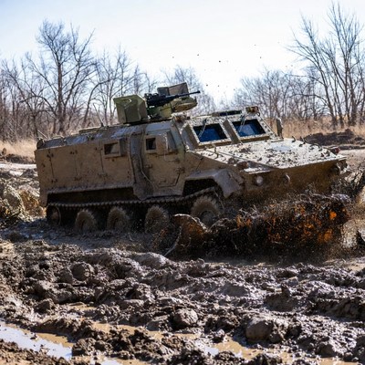 Military vehicle driving through mud