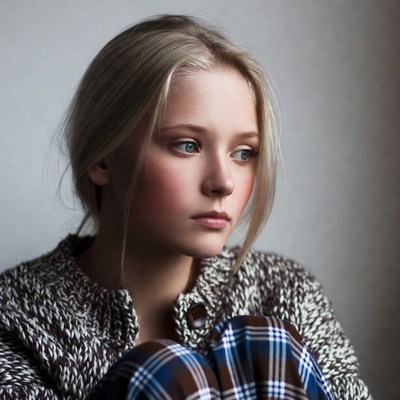 Blonde woman in sweater gazing sideways