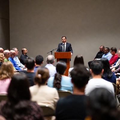 Man speaking at podium to audience