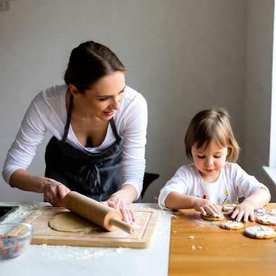 Mother and daughter rolling dough