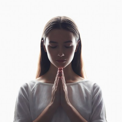 Woman praying with hands clasped silhouette
