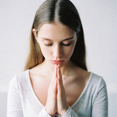 Woman praying with hands clasped