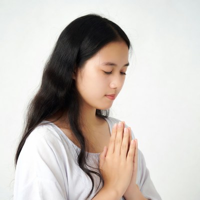 Asian girl praying with hands together