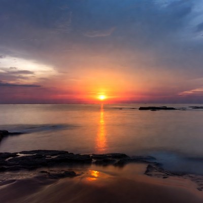 Sunset over ocean with rocks