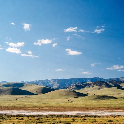 Green Rolling Hills Under Blue Sky