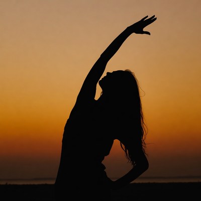 Woman Silhouette Stretching at Sunset