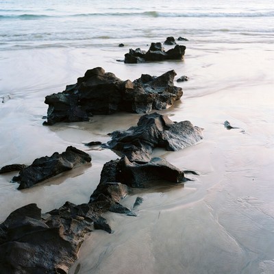 Black Rocks on Beach with Ocean Waves