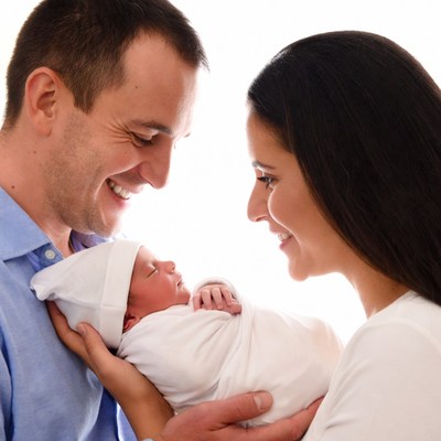 Parents smiling at newborn baby
