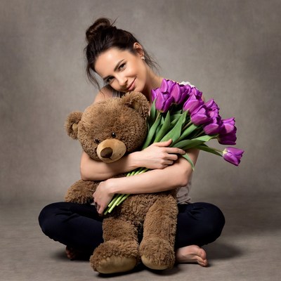 Woman hugging teddy bear with tulips