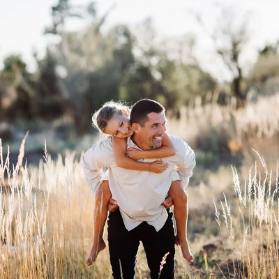 Father carrying daughter on shoulders