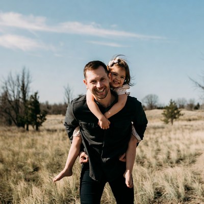 Father carrying smiling daughter on shoulders