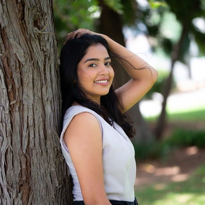 Indian woman leaning against tree