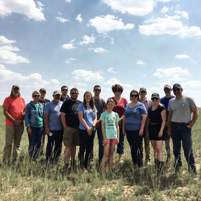 Group of people standing in grassy field