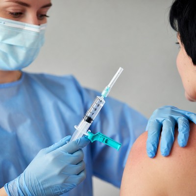 Nurse administering vaccine to woman