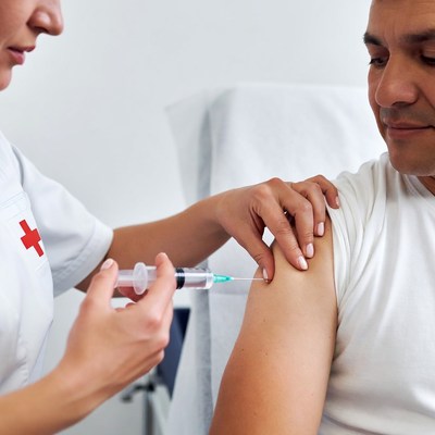 Nurse administering injection to man