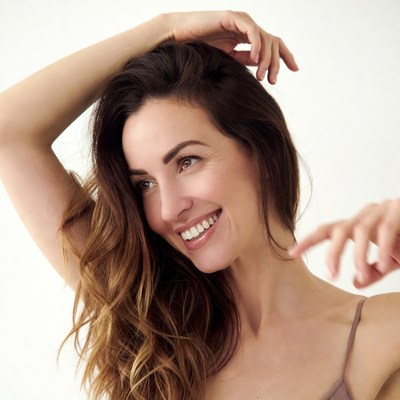 Smiling woman with hand on head