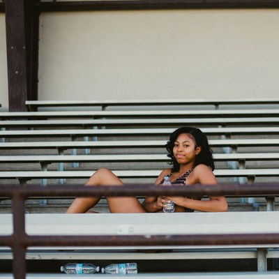 African-American woman on bleachers with water bottle