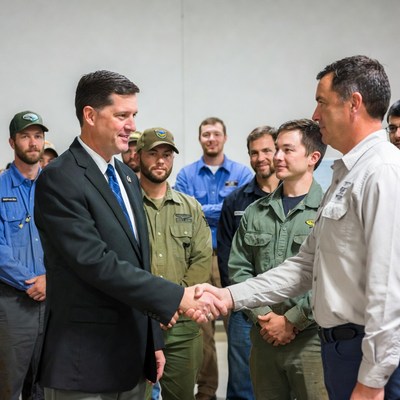Man in suit shaking hands with workers