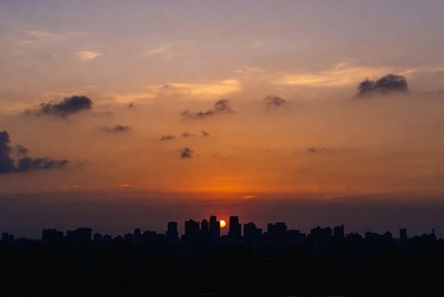 Sunset over City Skyline Silhouette