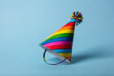 Rainbow party hat on blue background