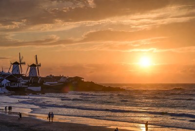 Windmills at sunset beach with people