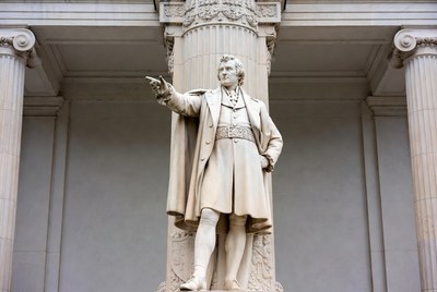 Man statue gesturing on column