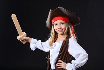 Girl in pirate costume holding wooden sword
