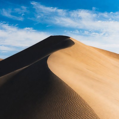 Curved Sand Dune Under Blue Sky