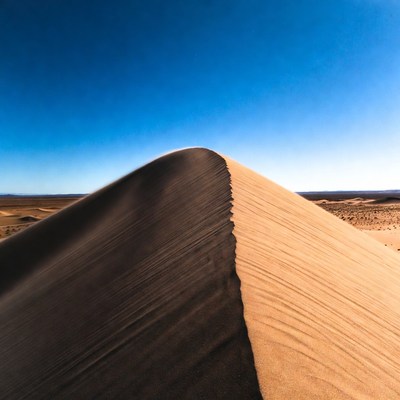 Sand Dune in Desert Under Blue Sky