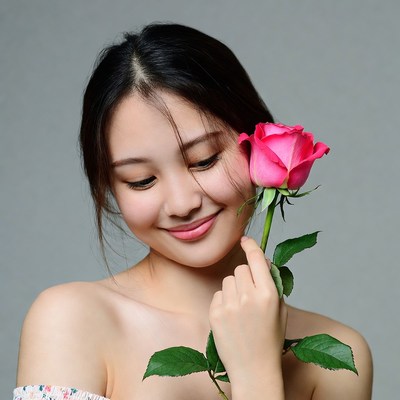 Asian woman holding pink rose