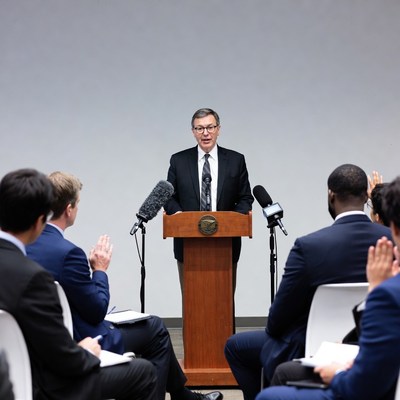 Man speaking at podium with audience