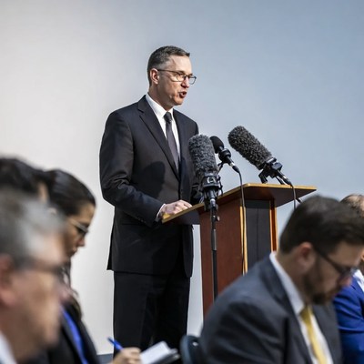 Man speaking at podium with audience