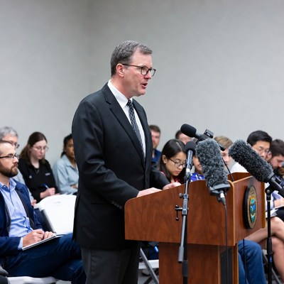 Man speaking at podium with audience