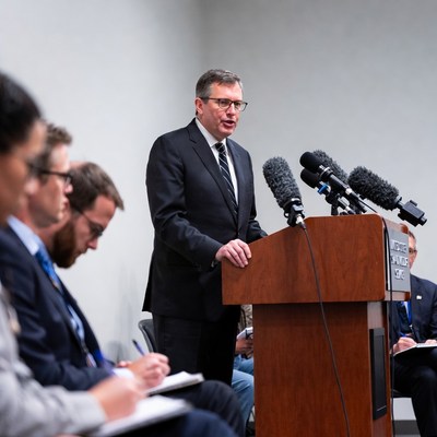 Man speaking at podium with audience