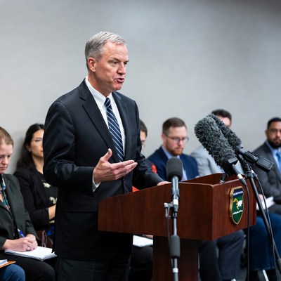 Man speaking at podium with audience