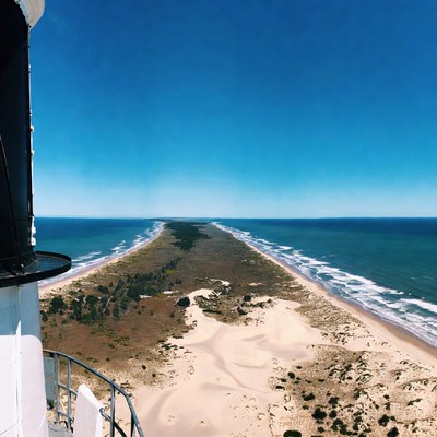Lighthouse overlooking sandy spit beach