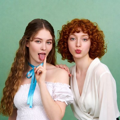 Two girls sticking tongues out