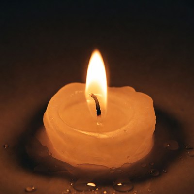 Burning Candle on Wet Surface