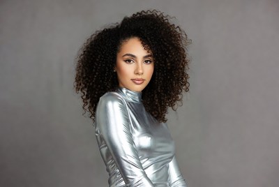 Woman in silver turtleneck with curly hair