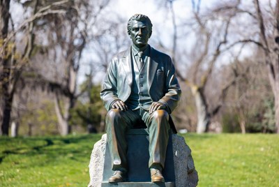 Bronze statue of seated man in suit